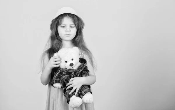 Играет со своим плюшевым другом. Очаровательная девочка с игрушечной игрушкой. Маленький ребенок обнимает плюшевого медвежонка. Маленькая девочка держит мягкую игрушку. Игрушка используется в игре, пространство для копирования — стоковое фото