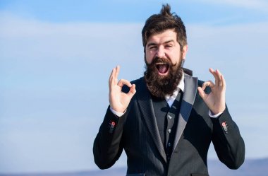 Umutlu ve gelecek hakkında kendinden emin. Tamam gesturing. Adam sakallı iyimser işadamı resmi takım elbise gökyüzü arka plan giymek. Başarı ve şans. İyimser bir ruh hali. İyimser gibi düşün. İyimser olmak