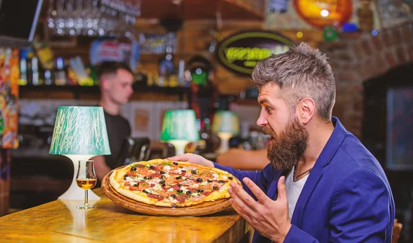 Cheat meal concept. Hipster hungry eat italian pizza. Pizza favorite restaurant food. Fresh hot pizza for dinner. Hipster client sit at bar counter. Man received delicious pizza. Enjoy your meal