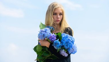 Sarışın bir kız ortanca çiçeği buketi tutuyor. Doğal güzellik konsepti. Cilt bakımı ve güzellik tedavisi. Narin bir kadın için nazik bir çiçek. Saf güzellik. Genç tenin hassasiyeti. Bahar çiçekleri