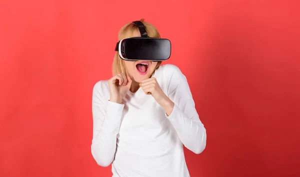 Nő izgatott a 3D-s szemüveg. Portré egy lenyűgözött lány egy virtuális valóság headset elszigetelt vörös háttérben. Nő használ VR készülék. Robotkar emberi. — Stock Fotó
