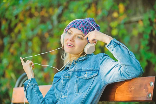 Cool funky girl enjoy music in headphones outdoor. Girl listen music in park. Melody sound and mp3. Music fan concept. Headphones must have modern gadget. Enjoy powerful sound. Feeling awesome