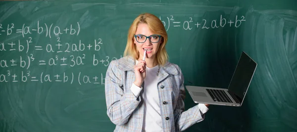 現代のラップトップサーフィンインターネット黒板の背景を持つ教育者スマートな賢い女性。デジタル技術の概念。彼女の心のアイデア。メガネを着用する女性教師は、ラップトップサーフィンインターネットを保持します — ストック写真
