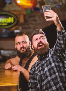 Adam hipster tutun smartphone sakallı. Alarak selfie kavramı. Selfie arkadaşlar sosyal ağlara göndermek. Adam bar bira içiyor. Harika akşam barda hatırlamak selfie fotoğraf çekmek. Online iletişim