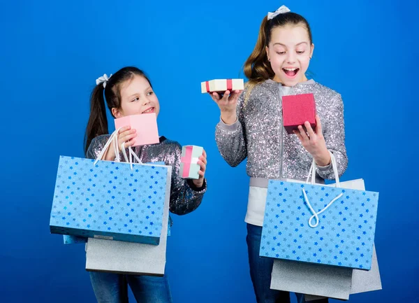 Moda infantil. Chicas hermanas amigas con bolsas de compras fondo azul. Cada producto entregado a usted. Compras y compras. Viernes Negro. Venta y descuento. Paquetes de niños. Día de compras —  Fotos de Stock