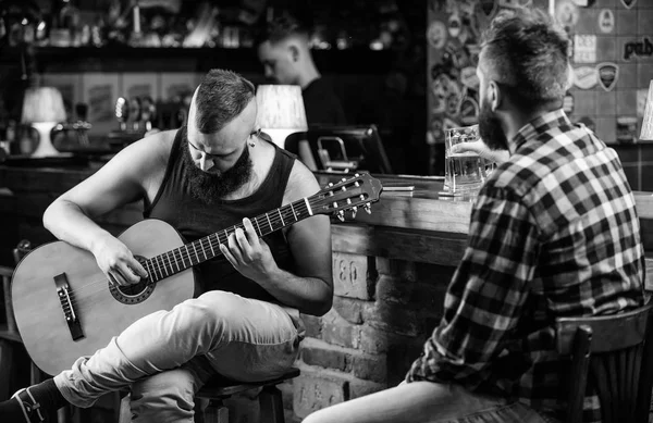 Sexta-feira relaxamento no bar. Amigos relaxando em bar ou pub. Hipster brutal barbudo passar o lazer com amigo no bar. Homens de verdade lazer. Amigos alegres relaxam com a música de guitarra. Homem toca guitarra no bar — Fotografia de Stock