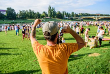 Kutlama nedenleri olması. Sakallı adam kutlama gününde kazanan jest yapıyor, geri görünümü. Hipster yaz manzara tatil kutlama zevk. Kutlamaya hoş geldiniz