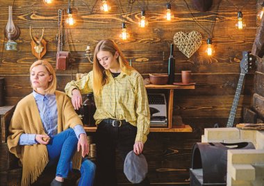 Arkadaş veya kız kardeşim hoş gamekeepers evde, iç arka plan akşamın. Ormanda kavramı tatil. Kızlar sakin yüzler üzerinde dinlenme yaparken sıcak atmosferinin keyfini çıkarın. Kızlar iyi tatiller