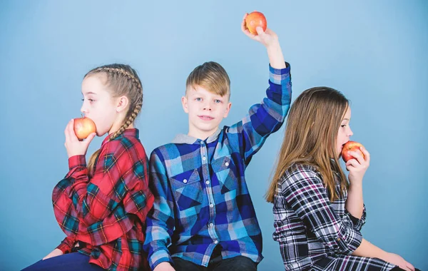 Здоровое питание и витамины. Мальчик и девочки друзья едят яблочные закуски во время отдыха. Концепция школьных закусок. Группа веселых подростков веселятся и едят яблоки. Подростки со здоровой закуской — стоковое фото