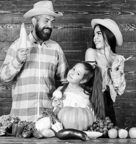 Γονείς και κόρη γιορτάζουν φθινόπωρο φεστιβάλ συγκομιδή. Ρουστίκ στυλ οικογένεια αγρότες στην αγορά με λαχανικά φρούτα και πρασινάδα. Οικογενειακό αγρόκτημα έννοια. Τους αγρότες της οικογένειας με φόντο ξύλινη συγκομιδή — Φωτογραφία Αρχείου