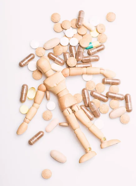 Receta médica. Maniquí humano de madera yacía en un montón de pastillas y tabletas. Toma el concepto de medicina. Salud y tratamiento. Atención médica y problemas. Inmunidad y vitaminas medicinales. Sobredosis y muerte — Foto de Stock