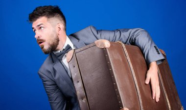 Retro bavullu bir iş gezisi. Ağır çanta. Olgun gezgin. Antika çantalı şık bir esthete. Resmi takım elbiseli sakallı adam. Papyonlu iş adamı şaşırdı. Çantasıyla tarzını tamamlıyor.