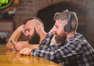 Cuma günü barda rahatlama. Hippi sakallı adam boş vakitlerini bar tezgahında geçiriyor. Bardan içki söyle. Kulaklıklı ve akıllı telefonlu adamlar barda dinleniyor. İletişimden kaçının. Gerçeklerden kaç.