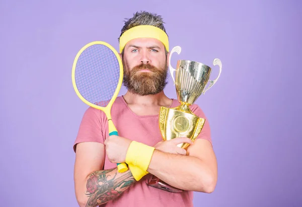 Hombre barbudo hipster llevar traje deportivo. Éxito y logro. Gana cada partido de tenis en el que participe. Jugador de tenis gana el campeonato. Atleta sostiene raqueta de tenis y copa dorada. Ganar tenis juego — Foto de Stock