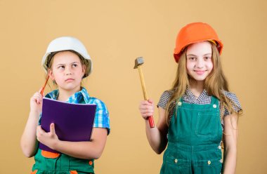 küçük kızlar atölyede birlikte tamir. Foreman müfettişi. Onarım. İşçi bayramı. 1 mayıs. mutlu çocuklar. Gelecekteki kariyeri. Tablet ve çekiçle miğferli küçük çocuklar. Gerçek profesyonel