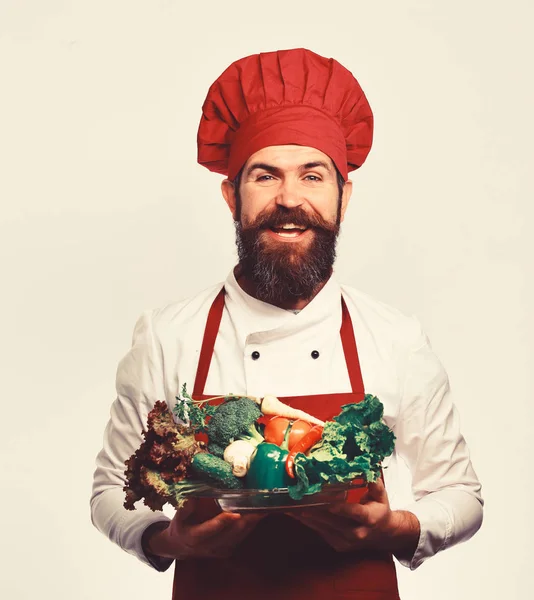 Man med skägg isolerad på vit bakgrund. Chef håller grönsaker. — Stockfoto