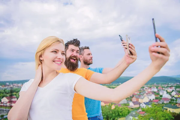 Todos somos individuos. A la gente le gusta fotografiar selfies en la naturaleza. Mejores amigos tomando selfie con el teléfono de la cámara. Chica sexy y hombres sosteniendo teléfonos inteligentes en las manos. Compartir selfie en las redes sociales — Foto de Stock