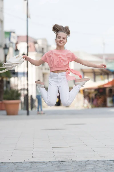 Egyre nagyobb és aktívabb. Aktív kislány mozgásban a városi háttér. Boldog kisgyerek jumping aktív öröm. Aktív és energikus gyerek szórakozik nyáron — Stock Fotó