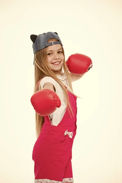 ボクシング グローブ白で隔離の幸せな女の子。小さな子供は、トレーニングやワークアウトの前に笑顔します。おしゃれなキャップで子供選手。ファッション、スタイル、トレンド。スポーツ活動とエネルギー — ストック写真