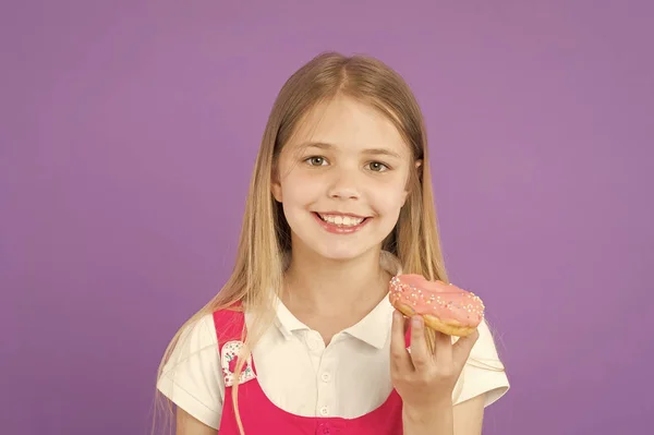 Criança sorrir com donut em fundo violeta. Menina com donut de anel envidraçado. Rapaz feliz com comida de plástico no fundo roxo. Comida e sobremesa. Infância e acolhimento de crianças — Fotografia de Stock