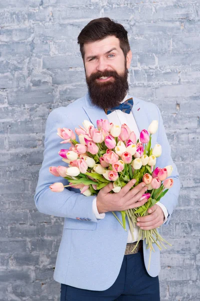 Leitfaden für den modernen Menschen. Romantiker mit Blumen. Romantisches Geschenk. Macho macht sich bereit für romantisches Date. Tulpen für den Liebsten. Mann gepflegten Smoking Fliege halten Blumenstrauß. wie man Gentleman wird — Stockfoto