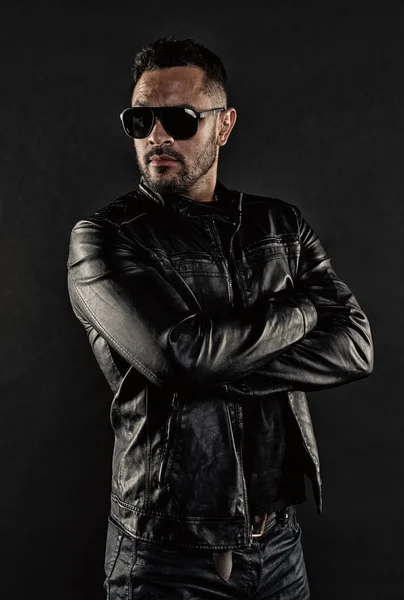 Man with beard has stylish look. Musuclar athlete in trendy clothes. Brutal macho in leather jacket. Bearded man in fashion sunglasses. Mens sexuality and attraction. Fashion model in sunglasses