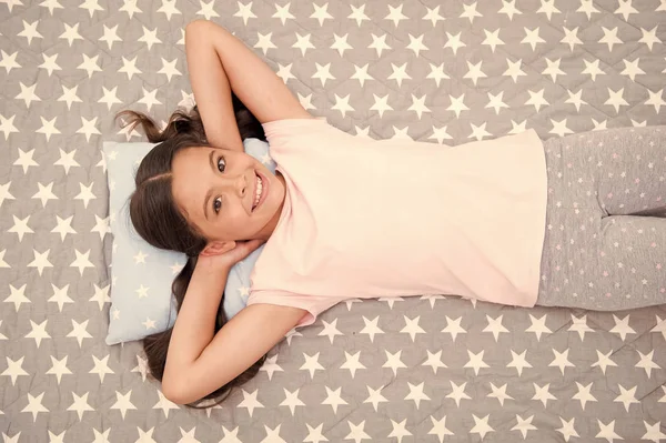 Girl child long hair lay awake top view. Quality of sleep depends on many factors. Girl lay on little pillow full of energy in morning bedclothes background. Choose proper pillow to sleep well