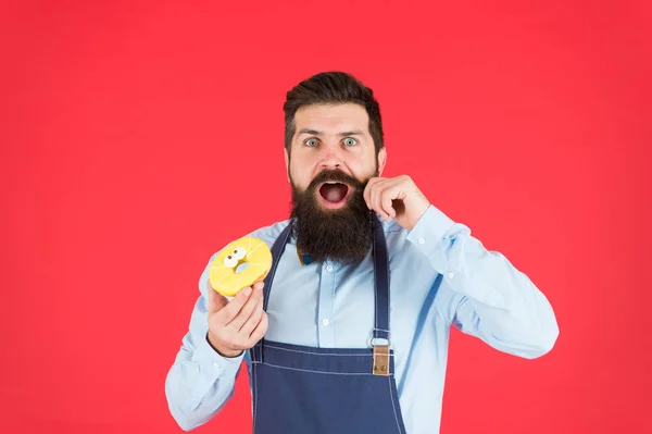 Bearded man in apron. Diet and healthy food. Doughnut diet. Calorie. Feel hunger. No diet. Chef man in cafe. baker hold donut. Funny hipster. Male deit. Being young means having fun