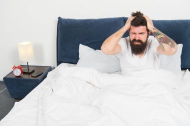yatakta pijama sakallı olgun erkek. yatak odasında acımasız uykulu adam. uykuda ve uyanık. Uyanmak için çok erken. enerji ve yorgunluk. Uykulu sakallı adam hipster sabah baş ağrısı ile. Sadece dinleniyor