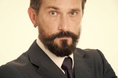 Olgun ve tecrübeli. Erkek yüzü sakallı ve bıyıklı, sakin. İş adamları kıyafet yönetmeliği. İş tarzı görünüş. İş adamı klasik resmi kıyafet modern detay küpesi