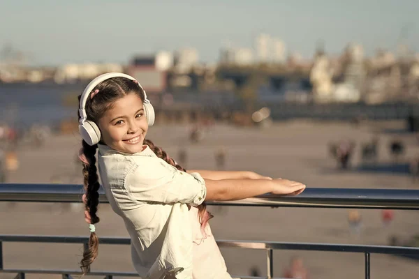 Não pares a música. Menina feliz usar fones de ouvido. Um pequeno fã de música. Criança ouça música ao ar livre. Criança feliz. Porque as ruas estão a cantar — Fotografia de Stock