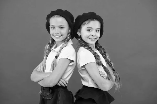 Su estilo perfecto. Chicas de moda con el pelo atado en trenzas. Chicas de estilo francés. Chicas lindas que tienen el mismo peinado. Niños pequeños con trenzas de pelo largo. Niños pequeños con boinas francesas elegantes — Foto de Stock