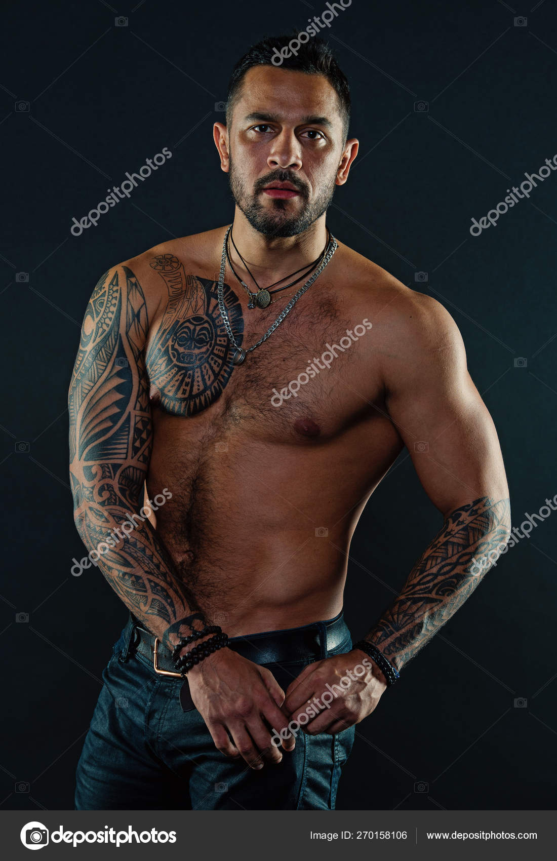 Bearded man with tattooed body. Macho with sexy bare torso in jeans. Tattoo model with six Bearded man with tattooed body. Macho with sexy bare torso in jeans. Tattoo model with six