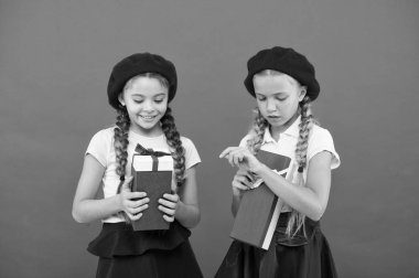 Küçük kızlar okul üniformalı çocuklar ve bere hediye kutuları tutun. Çocuk hediyeleri açma hakkında heyecanlı. Küçük şirin kızlar tatil hediye aldı. Mutluluk için çocukları getirin. Çocuklar için en iyi hediyeler