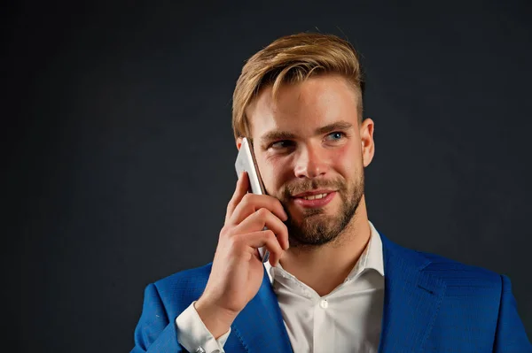 Empresario feliz sonriente utilizar la comunicación del teléfono inteligente, fondo negro. Hombre hablar de la oficina del teléfono celular. Hombre de traje hombre de negocios toma ventajas de las tecnologías móviles modernas. Concepto de llamada empresarial — Foto de Stock