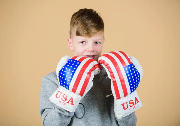 Start boxing career. American boxer concept. Child sporty athlete practicing boxing skills. Boxing sport. Towards victory. Confident in his strength. Boy sportsman wear boxing gloves with usa flag
