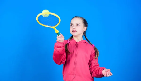 Active leisure and hobby. Tennis sport and entertainment. Girl adorable child play tennis. Practicing tennis skills and having fun. Great day to play. Athlete kid tennis racket on blue background