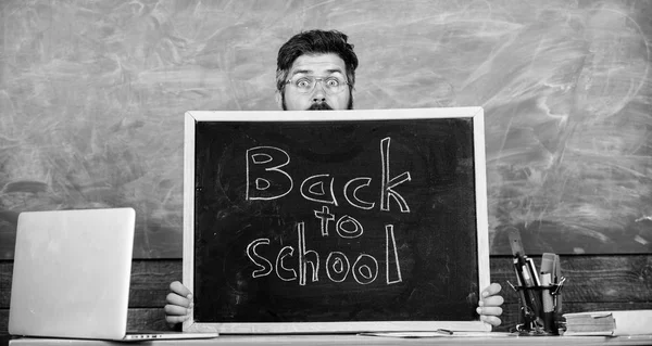 Teacher or school principal welcomes inscription back to school. School life full of stress. Educator hiding behind blackboard. Man scared beginning school year. Teacher peeking out of blackboard — Stock Photo, Image