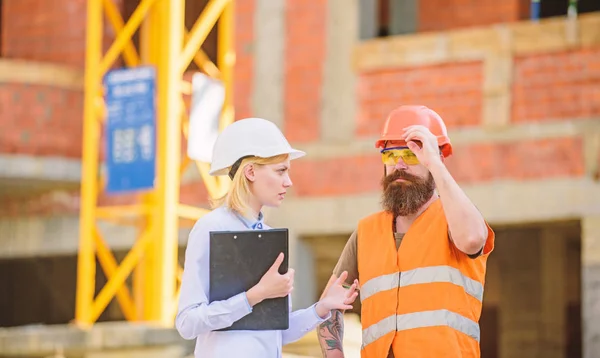 Inspecteur et bâtisseur barbu brutal discuter des progrès de la construction. Inspection du projet de construction. Inspection de construction, corrections et amendes. Discuter du projet en cours. Concept d'inspecteur de sécurité — Photo