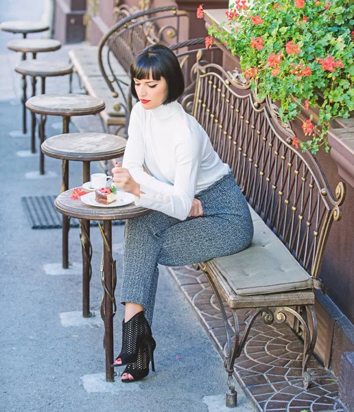 Kvinna attraktiv brunett äter gourmet tårta café terrass bakgrund. Gastronomisk njutning. Flicka koppla av café med kaka dessert. Trevlig tid och avkoppling. Gourmet-konceptet. Utsökt gourmet tårta — Stockfoto