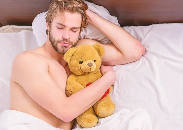 Un joven despertando en la cama y estirando los brazos. Pies de hombre durmiendo en una cama cómoda. Despierta. . — Foto de Stock