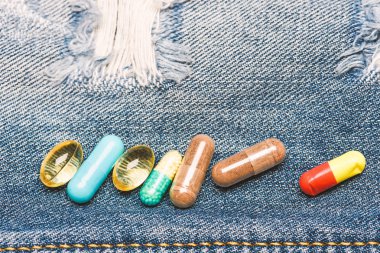 Uyuşturucu denim arka plan üzerinde. Renkli hapları kümesi. İlaçlar karıştırma. Hızlı tedavi. İlaç reçete. Sağlık ve hastalık. Doz ve bağımlılığı. Uyuşturucu bağımlılığı. İlaç ve tedavi kavramı