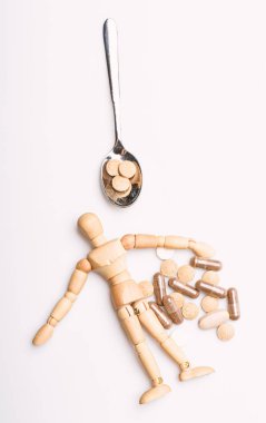 Ahşap insan kukla kaşık tam hapları ve tablet. Tıp kavramı al. Sağlık ve tedavi. Sağlık ve sorunları. Dokunulmazlık ve tıp vitaminler. Aşırı doz ve ölüm. İlaç reçete