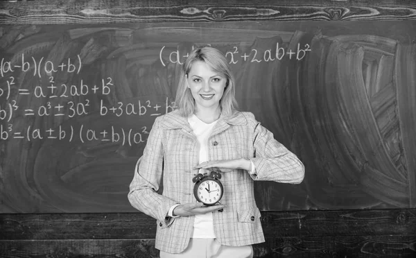 Time to study. Welcome teacher school year. Experienced educator start lesson. What time is it. She cares about discipline. Woman teacher hold alarm clock. Girl formal wear school lecturer — Stock Photo, Image