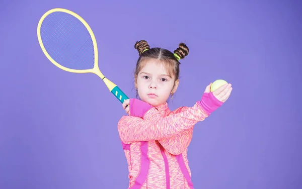 Active games. Sport upbringing. Small cutie likes tennis. Sport equipment store. Play tennis for fun. Little baby sporty costume play tennis game. Girl cute child double bun hairstyle tennis player — Stock Photo, Image