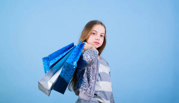 Fashion girl customer. Happy child in shop with bags. Shopping day happiness. Birthday girl shopping. Fashion boutique. Fashion trend. Fashion shop. Little girl with bunch packages. Seasonal sale