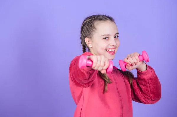 Débutant exercices haltère. Enfant tenir petit fond violet haltère. Sport pour adolescents. Exercices faciles avec haltère. Vers un corps plus sain. Concept de réhabilitation. Fille exercice avec haltère — Photo