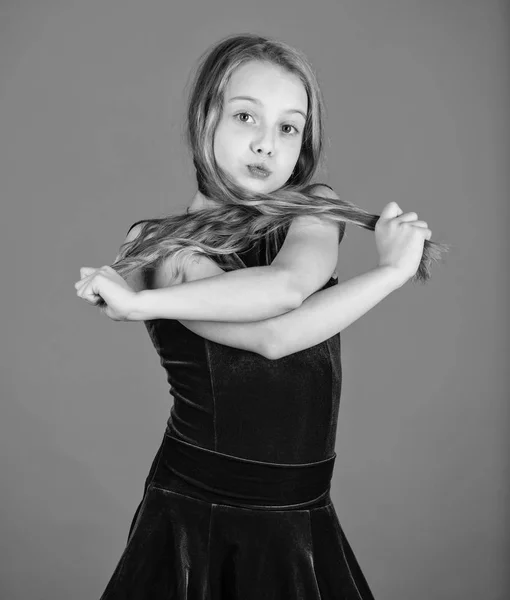 How to make tidy hairstyle for kid. Things you need know about ballroom dance hairstyle. Ballroom latin dance hairstyles. Kid girl with long hair wear dress on blue background. Hairstyle for dancer