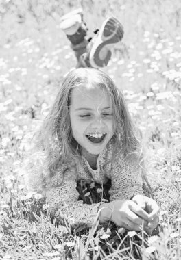 Çimen, grassplot arka plan üzerinde yatan kız. Çocuk ihale papatya çiçekleri ile çayır yalan ise bahar güneşli hava keyfini çıkarın. Kız mutlu yüz rahatlatıcı üzerinde. Bahar tatil kavramı