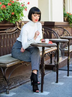 Keyifli zaman ve rahatlama. Lezzetli gurme kek. Kendini şımart. Kız pasta tatlısı ile kafe dinlenmek. Kadın çekici zarif esmer gurme kek cafe teras arka plan yemek. Gurme konsepti